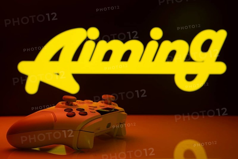 Dhaka, Bangladesh- 20 Mar 2025: A close-up of a white gamepad with the Aiming Inc seen on screen in the background