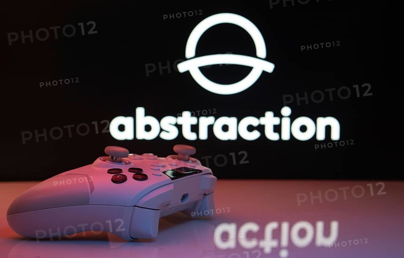 Dhaka, Bangladesh- 20 Mar 2025: A close-up of a white gamepad with the Abstraction seen on screen in the background