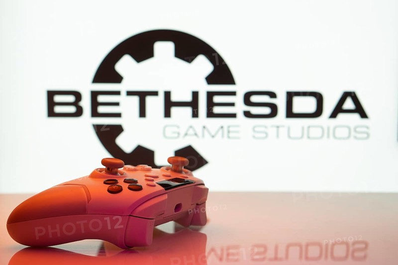 Dhaka, Bangladesh- 20 Mar 2025: A close-up of a white gamepad with the Bethesda Game Studios seen on screen in the background