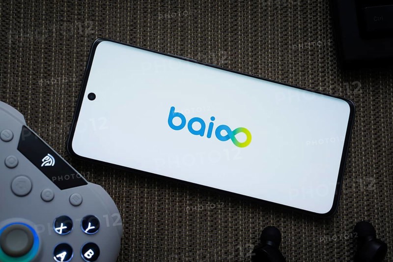 Dhaka, Bangladesh- 22 Mar 2025: Baioo Family Interactive Ltd logo displayed on a smartphone screen with a gaming controller and earbud visible