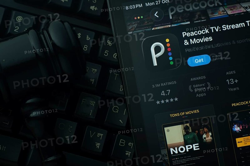 Dhaka, Bangladesh- 28 Oct 2025: An iPad displaying the Peacock TV app against a judge's gavel and dark keyboard background