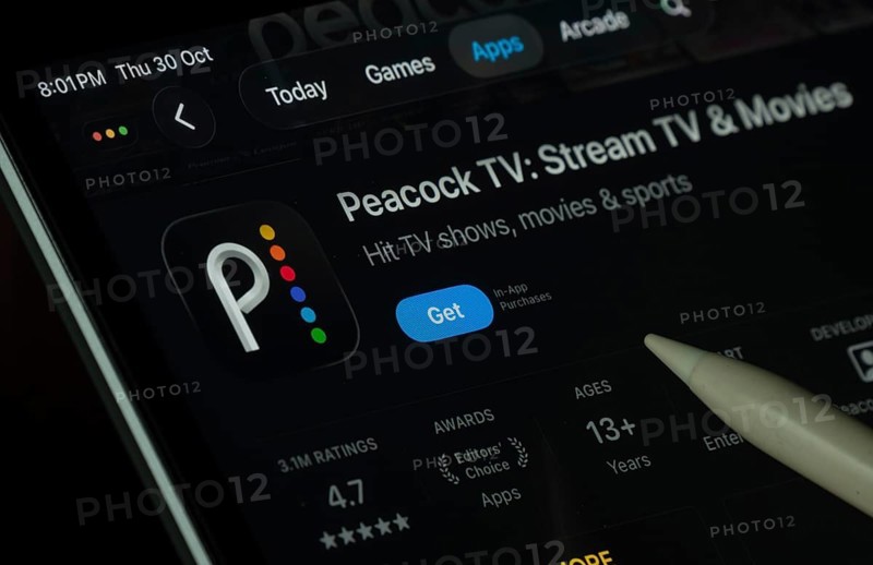 Dhaka, Bangladesh- 30 Oct 2025: Peacock TV app displayed on a iPad screen in dark mode with a digital pen pointing at it