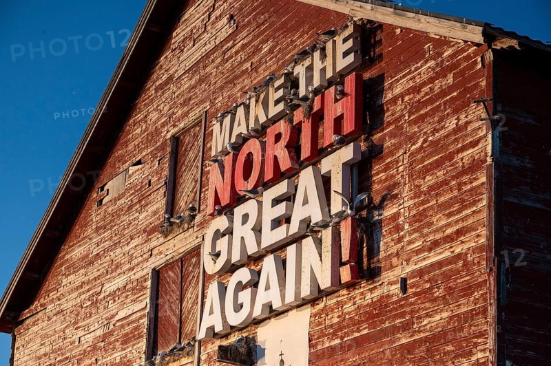 Red fishing building with the inscription Make the North great again at Vardö harbour, Vardø, Finnmark, Norway