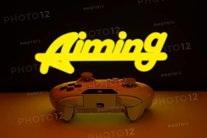 Dhaka, Bangladesh- 08 Apr 2025: A gaming controller in front of a Aiming Inc screen