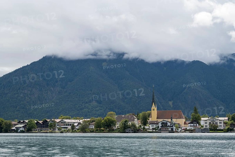 View from the Point peninsula of the district of Egern, parish church of St. Lawrence, behind Wallberg with clouds, Tegernsee, Rottach-Egern, Upper Bavaria, Bavaria, Germany