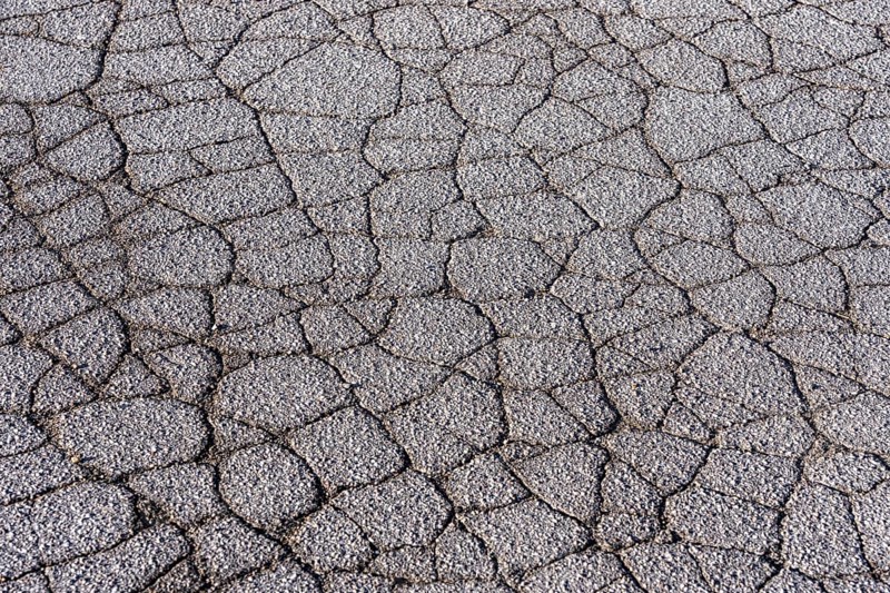 Asphalt surface, floor, with many small cracks, roadway, parking lot