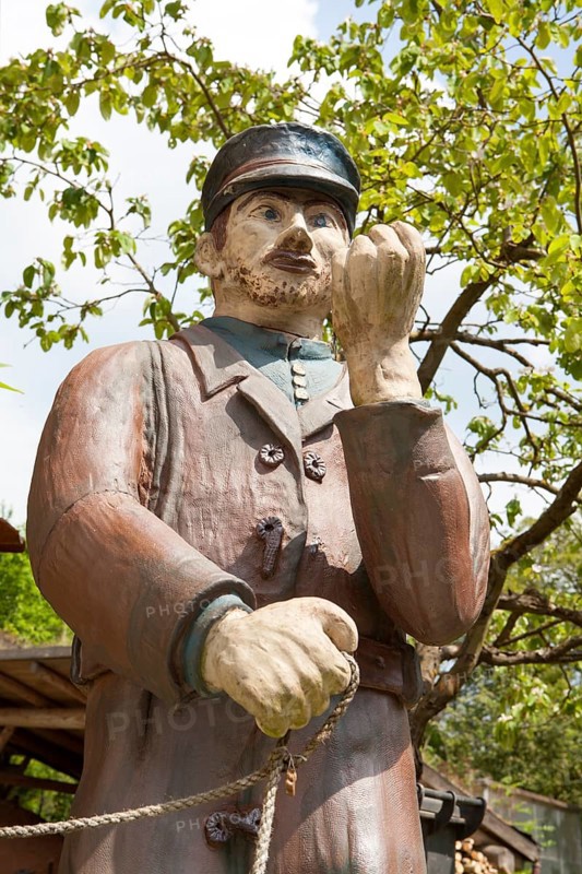 A man with dogs as a ceramic figure stands in front of the Keramik.um, an exhibition house dedicated to the history of Fredelsloh's pottery trade, Fredelsloh, Lower Saxony, Germany