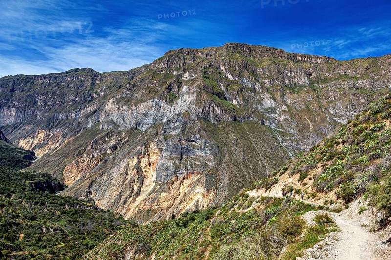 Path along a rocky mountain face under blue sky, the landscape of Colca Canyon in the Aden of Peru