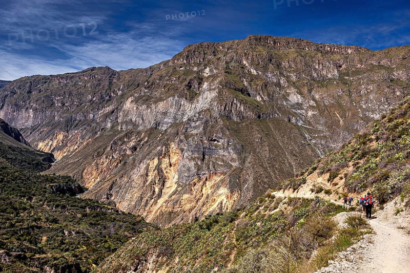 People hiking on a trail along a mountain edge, the landscape of Colca Canyon in the Aden of Peru
