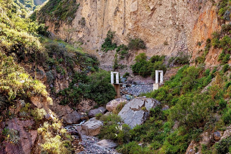 Small bridge over a rocky gorge surrounded by lush vegetation, The landscape of Colca Canyon in the Aden of Peru