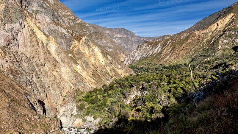 Extensive mountain range with green vegetation and blue sky, the landscape of Colca Canyon in the Aden of Peru