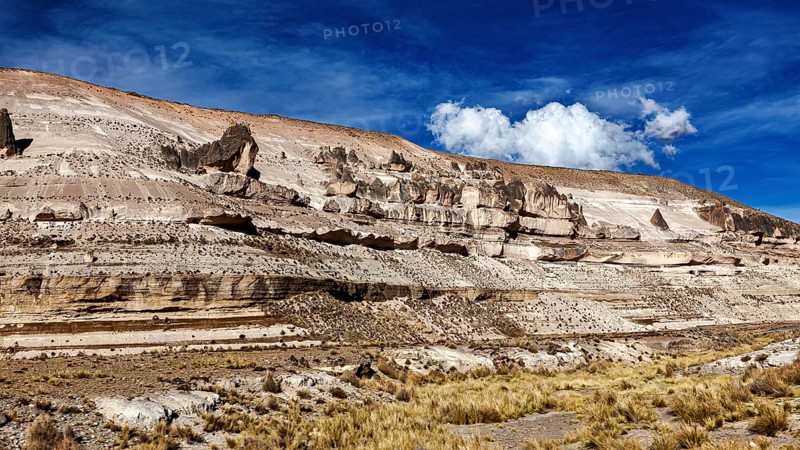 Stratified rock formations with blue sky and sparse clouds, The Andean highlands of Peru