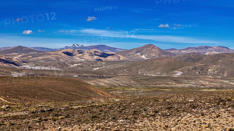Hilly landscape with extensive desert and mountain range in the background, The Andean highlands of Peru