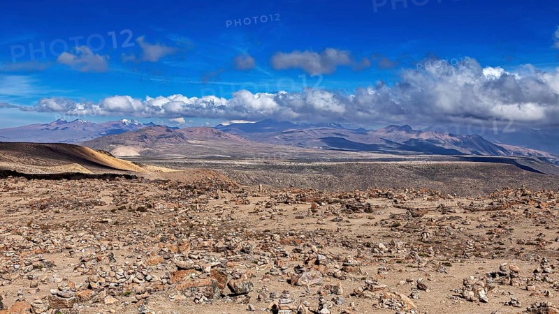 Stone area under blue sky with rising clouds in the distance, The highlands of the Andes of Peru