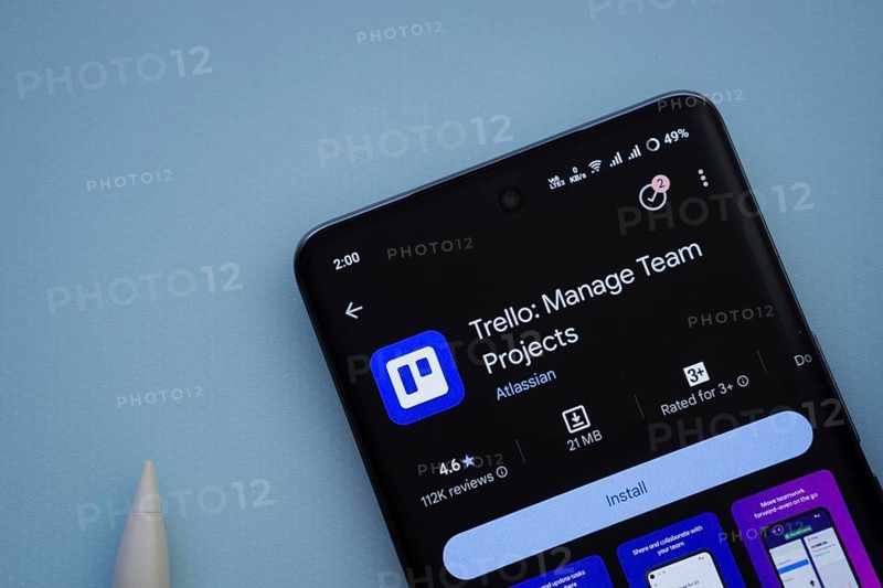 Dhaka, Bangladesh- 29 May 2025: On a blue surface, a smartphone displays the Trello app within the Google Play Store