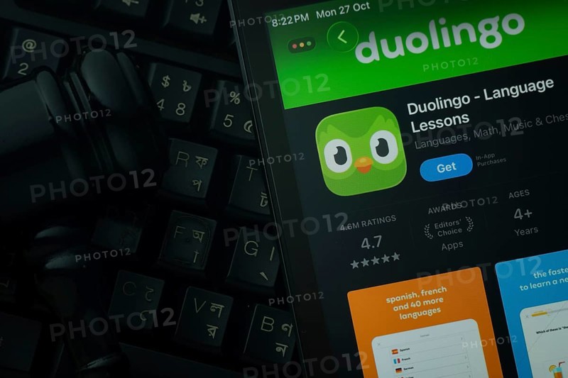 Dhaka, Bangladesh- 28 Oct 2025: An iPad displaying the Duolingo app against a judge's gavel and dark keyboard background