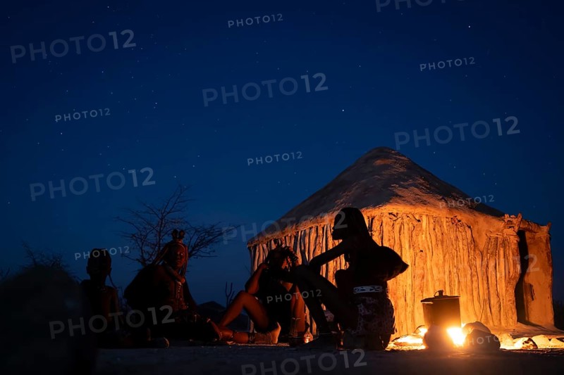 Himba at the campfire in the evening, night view, Himba huts, traditional Himba village in the savanna, Kaokoveld, Kunene, Namibia