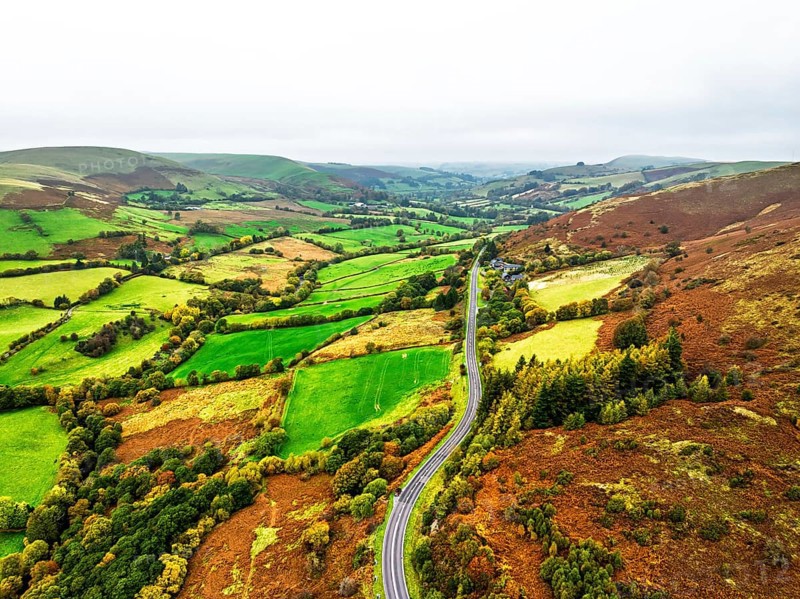 Autumn colours of Farms over River Wye and Road A470 from a drone, Llanidloes, Powys, Montgomeryshire, Wales, UK