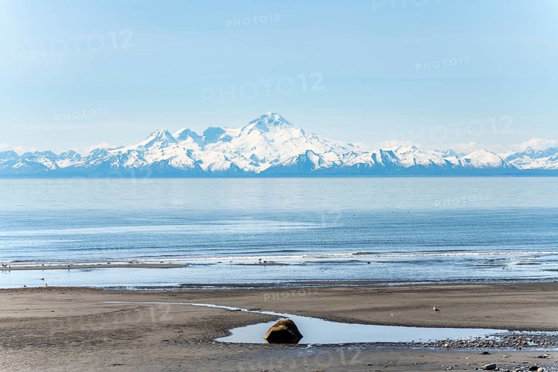 Beach at Anchor Point, Cook Inlet, glaciated mountain peaks of the Aleutian Range with Mount Iliamna summit, Anchor River State Recreation Area, Alaska, USA