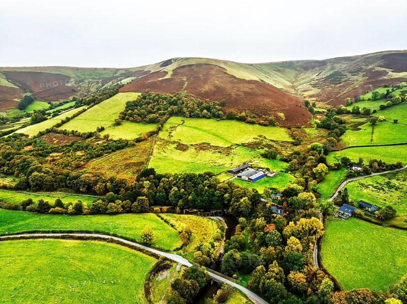 Autumn colours of Farms over River Wye and Road A470 from a drone, Llanidloes, Powys, Montgomeryshire, Wales, UK