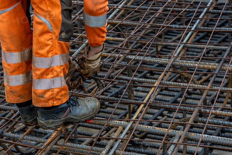 Assembly of reinforcing steel for the reinforced concrete foundation of a wind turbine, a mesh of rebar and reinforcing steel mesh, connecting the steel elements with binding wire, twisting with tongs, over 100 tons of reinforcing steel were used, the wind turbine will have a hub height of 160 meters, part of a new wind farm in Sauerland, near Balve, North Rhine-Westphalia, Germany