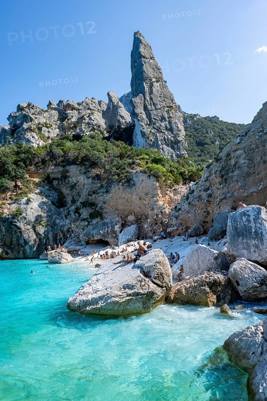Light blue clear sea on a dream beach on Cala Goloritzé, picturesque rocky coast, steep coast with rock pin L'Aguglia, Golfo di Orosei, Baunei, Sardinia, Italy