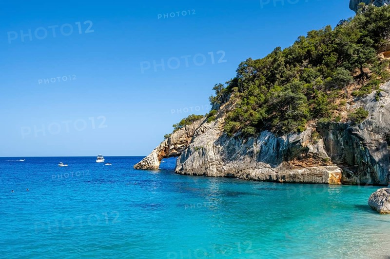 Light blue clear sea on a dream beach on Cala Goloritzé, picturesque rocky coast, cliffs with rock arch, Golfo di Orosei, Baunei, Sardinia, Italy