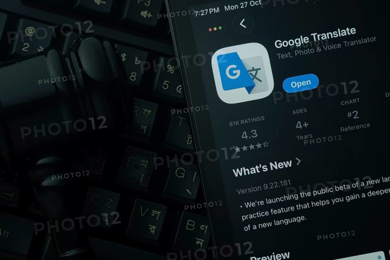 Dhaka, Bangladesh- 28 Oct 2025: An iPad displaying the Google Translate app against a judge's gavel and dark keyboard background