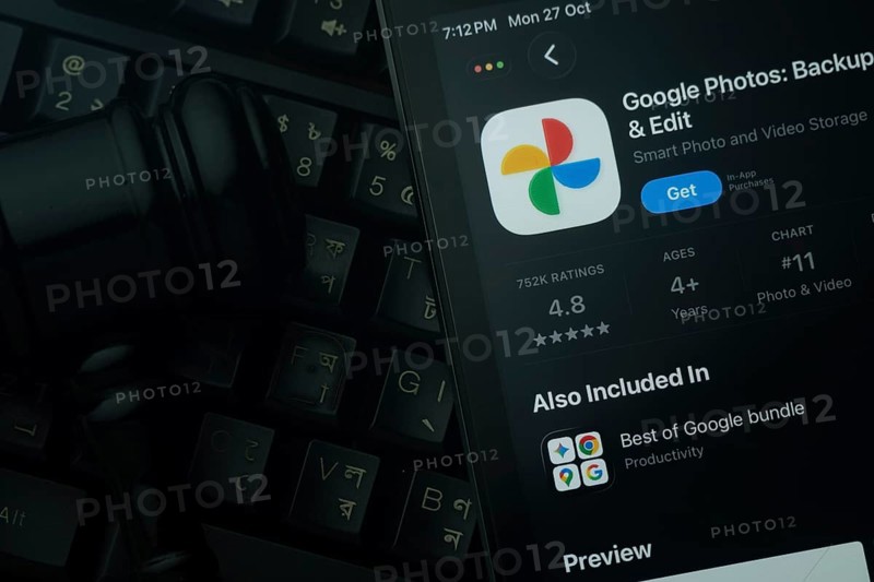 Dhaka, Bangladesh- 28 Oct 2025: An iPad displaying the Google Photos app against a judge's gavel and dark keyboard background