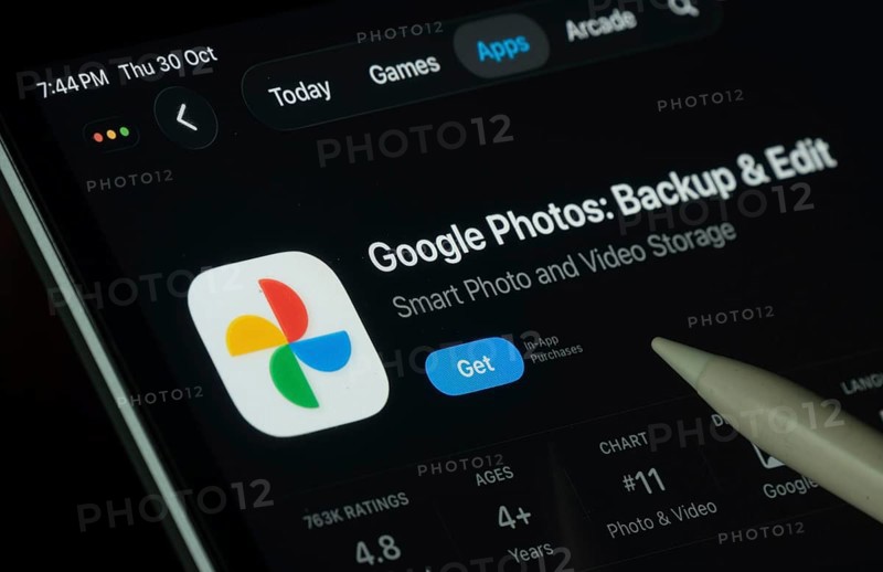 Dhaka, Bangladesh- 30 Oct 2025: Google Photos app displayed on a iPad screen in dark mode with a digital pen pointing at it