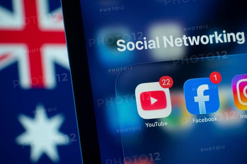 Dhaka, Bangladesh- 01 Dec 2025: A smartphone screen displays the Youtube and Facebook app with an Australian flag in the background. Australia to ban children from using social media