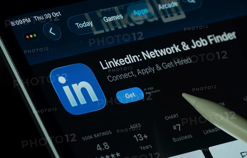 Dhaka, Bangladesh- 30 Oct 2025: LinkedIn app displayed on a iPad screen in dark mode with a digital pen pointing at it