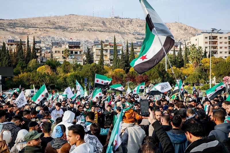 Damascus, Syria. November 28, 2025: Thousands of Syrians gather in Umayyad Square in central Damascus to celebrate the anniversary of the military operation that led to the fall of Bashar al-Assad's regime. Demonstrators express joy and unity while denouncing Israeli attacks on Syrian territory, Damascus, Damascus, Syria