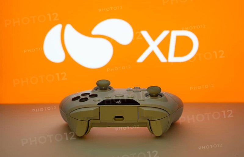 Dhaka, Bangladesh- 14 Nov 2025: A close-up of a white gamepad with the XD seen on screen in the background