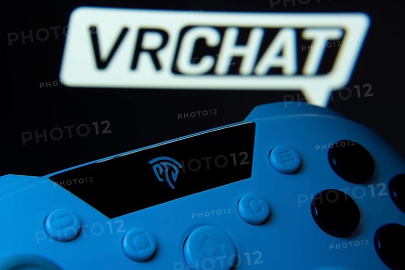 Dhaka, Bangladesh- 14 Nov 2025: A close-up of a gamepad with the VRChat seen on screen in the background