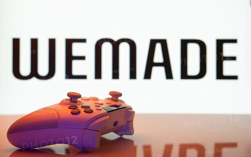 Dhaka, Bangladesh- 14 Nov 2025: A close-up of a white gamepad with the WeMade Entertainment seen on screen in the background