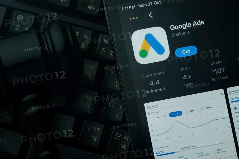 Dhaka, Bangladesh- 28 Oct 2025: An iPad displaying the Google Ads app against a judge's gavel and dark keyboard background
