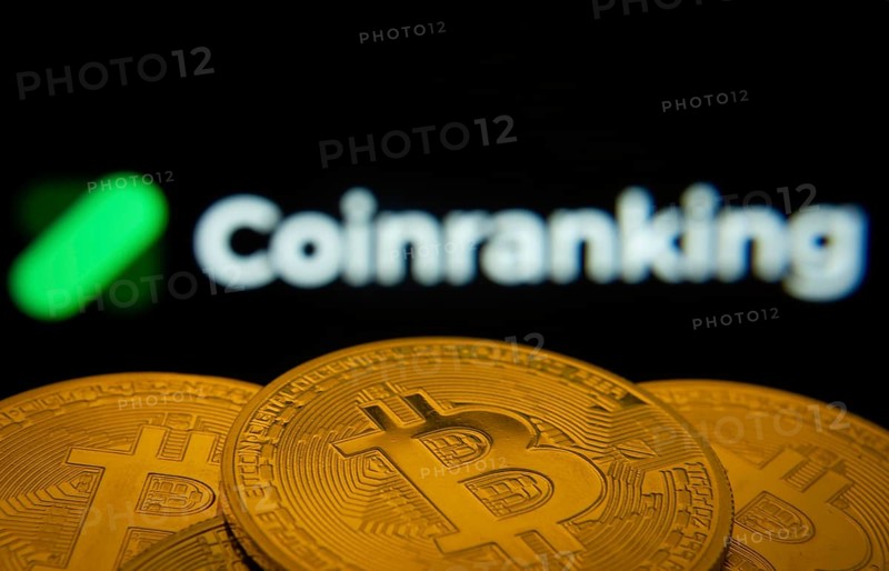 Dhaka, Bangladesh- 19 Sep 2025: Close-up of Bitcoin coins with the Coinranking logo visible on a screen in the background