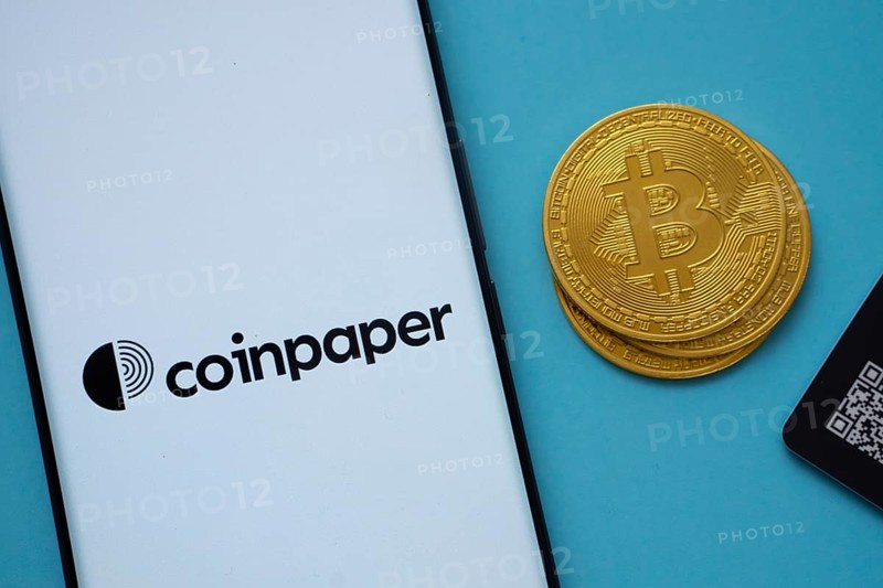 Dhaka, Bangladesh- 03 Sep 2025: Coinpaper logo on smartphone screen near Bitcoin coin and QR code on blue background