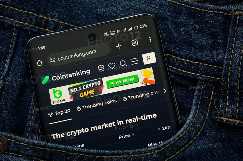 Dhaka, Bangladesh- 15 June 2025: A smartphone displaying the Coinranking web interface peeks out of a denim pocket