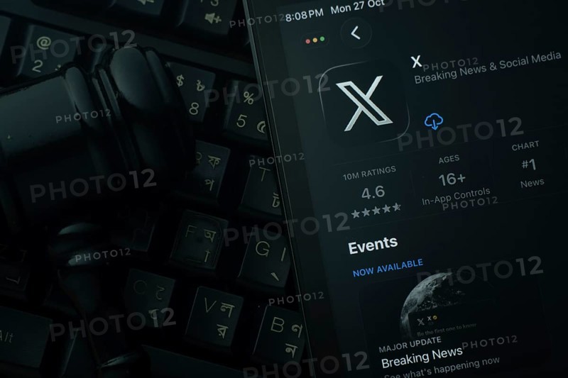 Dhaka, Bangladesh- 28 Oct 2025: An iPad displaying the X app against a judge's gavel and dark keyboard background