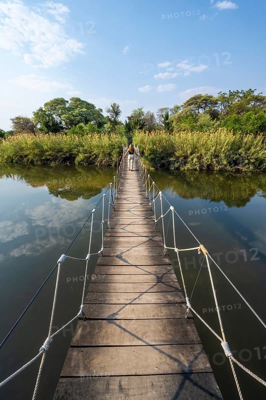 Toruist on the Kavango River, suspension bridge at Camp Kwando, Zambezi region, Caprivi Strip, Namibia