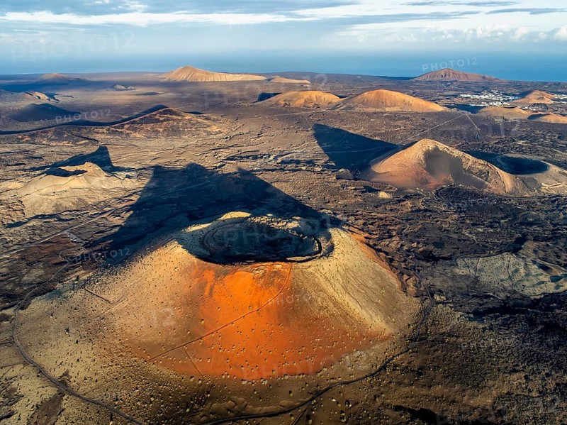 Caldera Colorada volcano, picturesque volcanic landscape with volcanic craters and lava fields in morning light, Parque Natural de Los Volcanes, aerial view, Lanzarote, Canary Islands, Spain