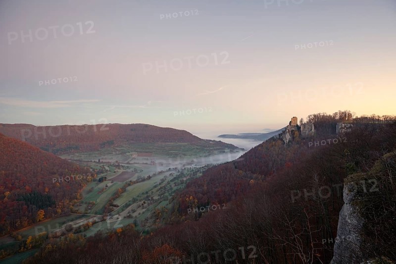 Sunrise with fog in the Neidlinger Valley with a view of the Reussenstein castle ruins. Swabian Jura, Baden-Württemberg, Germany