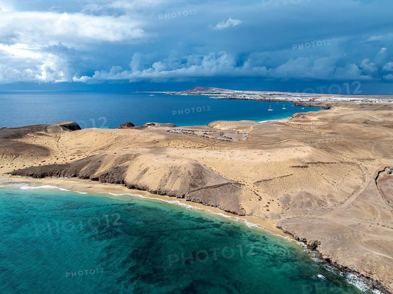 Coast with Playa Caleta del Congrio beach and blue sea, arid landscape of Los Ajaches Natural Park, aerial view, Lanzarote, Canary Islands, Spain