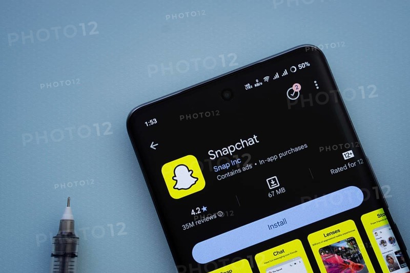 Dhaka, Bangladesh- 29 May 2025: On a blue surface, a smartphone displays the Snapchat app within the Google Play Store