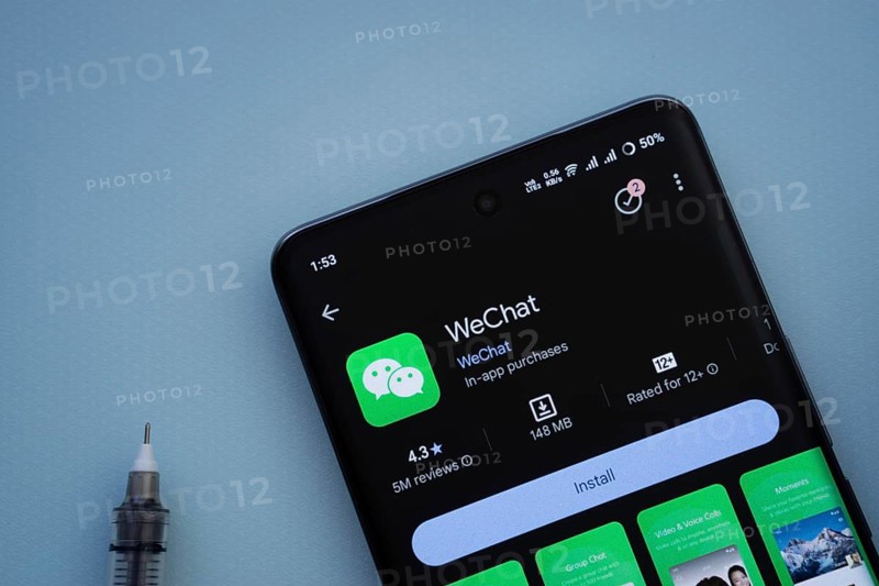 Dhaka, Bangladesh- 29 May 2025: On a blue surface, a smartphone displays the wechat app within the Google Play Store