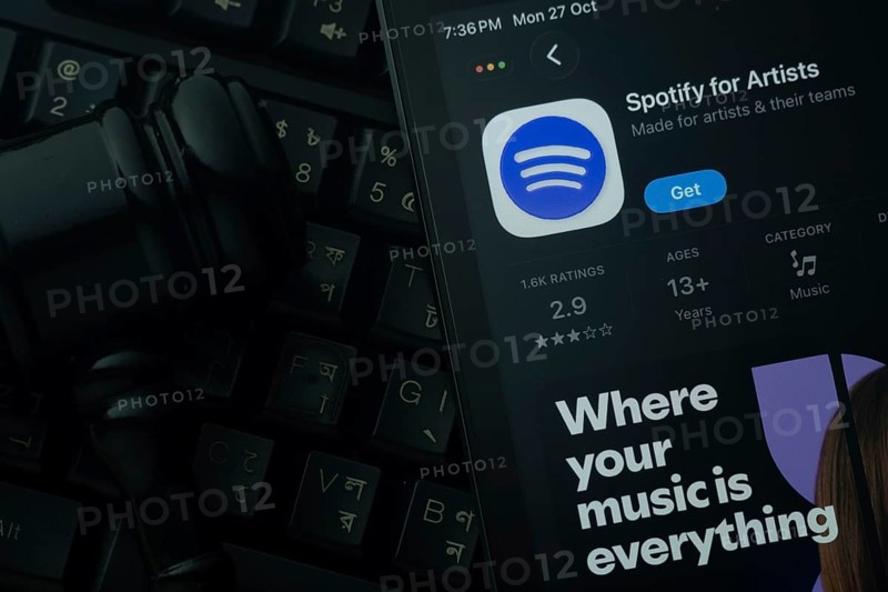 Dhaka, Bangladesh- 28 Oct 2025: An iPad displaying the Spotify for Artist app against a judge's gavel and dark keyboard background