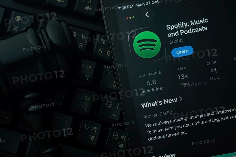 Dhaka, Bangladesh- 28 Oct 2025: An iPad displaying the Spotify app against a judge's gavel and dark keyboard background