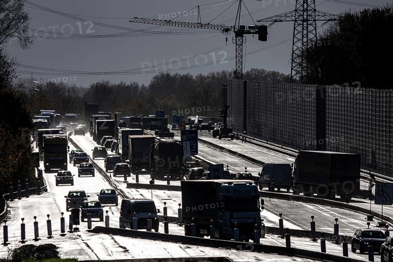 Highway construction site, the A57 is extended to 6 lanes on the section between the Meerbusch motorway junction and the Oppum junction, traffic runs parallel to 2 narrowed lanes, wet road after rain shower, Krefeld, North Rhine-Westphalia, Germany